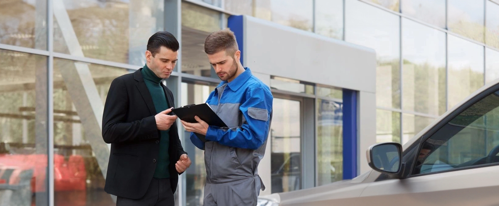 Two men standing next to each other holding a tablet.